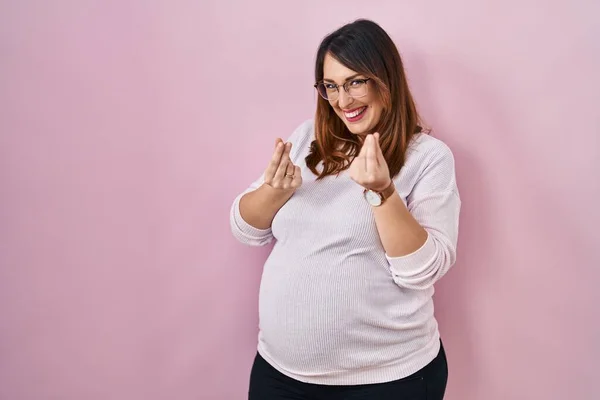 Zwangere Vrouw Staan Roze Achtergrond Doen Geld Gebaar Met Handen — Stockfoto