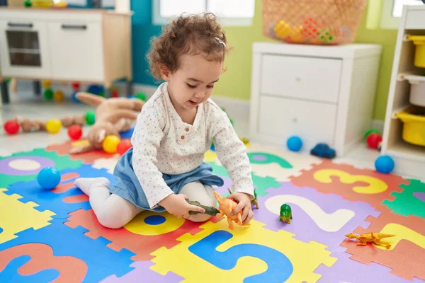 可敬的是 他那惊慌失措的小孩竟然坐在幼儿园的地板上玩恐龙玩具 — 图库照片
