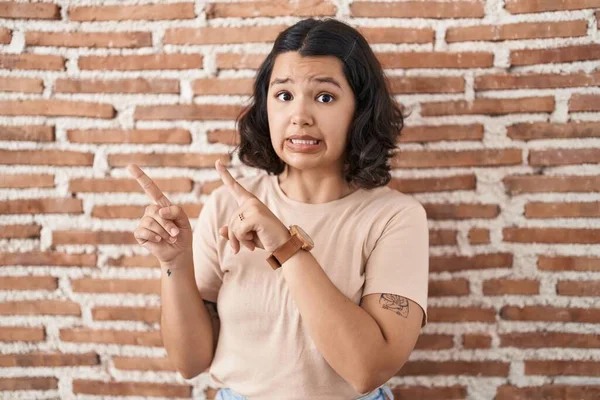 Young Hispanic Woman Standing Bricks Wall Pointing Aside Worried Nervous — ストック写真