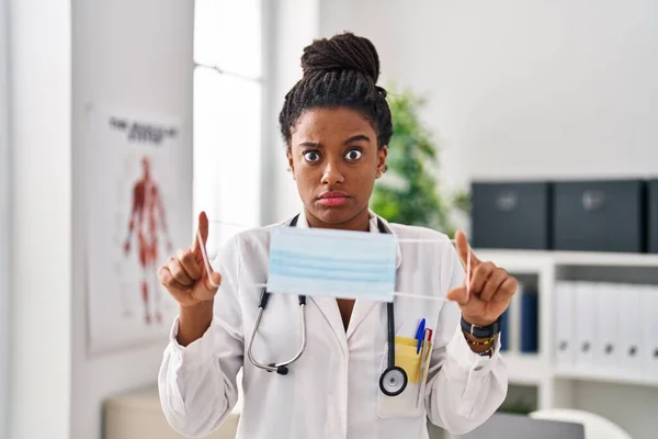 Young African American Braids Wearing Doctor Uniform Holding Safety Mask —  Fotos de Stock