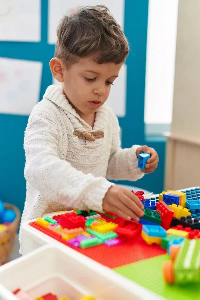 stock image Adorable hispanic toddler playing with construction blocks standing at kindergarten