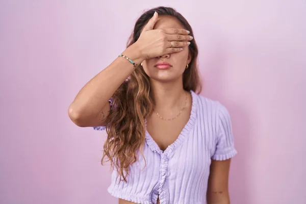 Молодая Латиноамериканка Стоящая Розовом Фоне Закрывая Глаза Рукой Выглядит Серьезной — стоковое фото