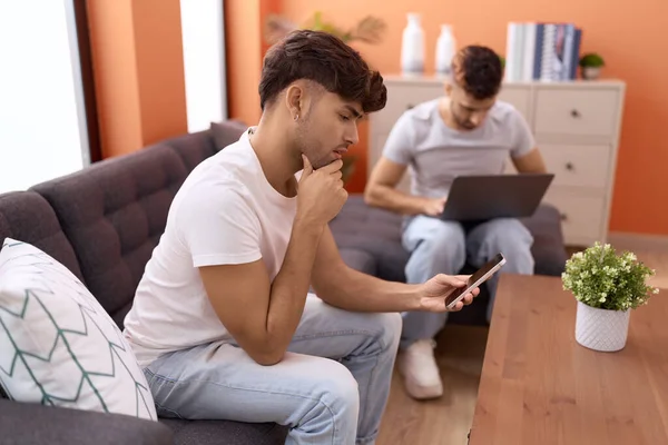 Two Hispanic Men Couple Using Laptop Smartphone Sitting Sofa Home — Stock Photo, Image
