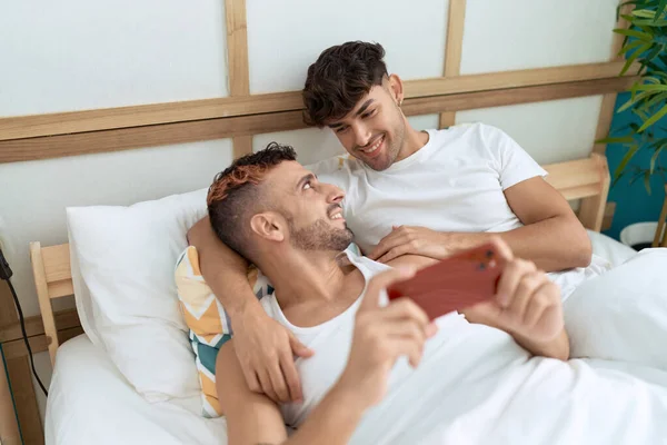 Два Латиноамериканца Лежали Постели Смотрели Видео Смартфоне Спальне — стоковое фото