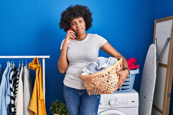 Black Woman Curly Hair Holding Laundry Basket Speaking Phone Relaxed — ストック写真