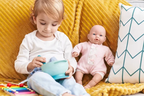 Evdeki Kanepede Oturan Sevimli Beyaz Kız Oyuncak Bebekle Oynuyor — Stok fotoğraf