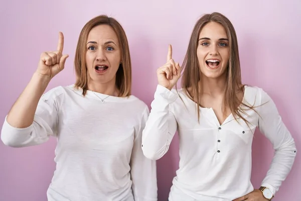 Middle Age Mother Young Daughter Standing Pink Background Pointing Finger — Stock Photo, Image