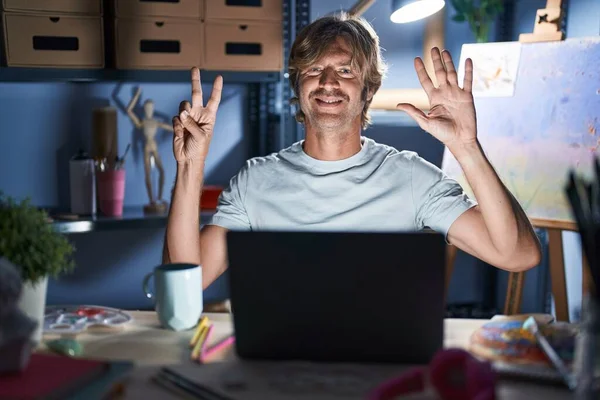Middle Age Man Sitting Art Studio Laptop Night Showing Pointing — Stockfoto