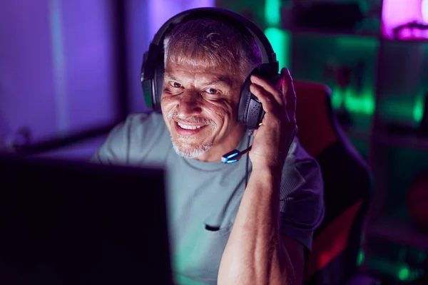 中年灰发男人在游戏室用电脑玩电子游戏 — 图库照片