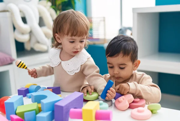 stock image Two kids playing with construction blocks standing at kindergarten