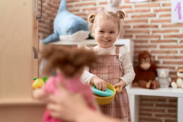 可爱的高加索女孩站在幼儿园里玩着游戏厨房 — 图库照片