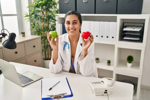 Young Hispanic Woman Working Dietitian Clinic Holding Green Apple Smiling — Foto de Stock