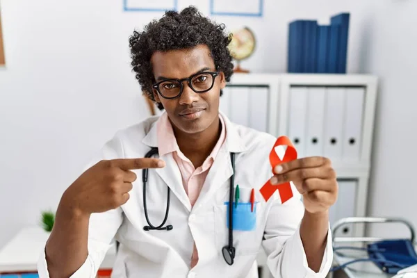 African Doctor Man Holding Support Red Ribbon Smiling Happy Pointing — Fotografia de Stock