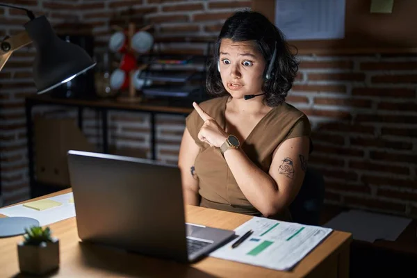 Young Hispanic Woman Working Office Night Pointing Aside Worried Nervous — ストック写真