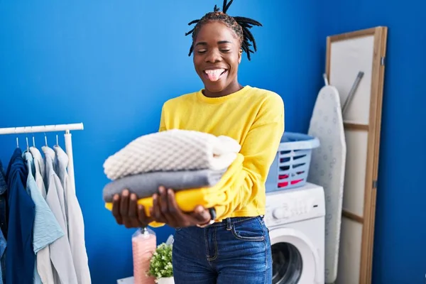 Beautiful Black Woman Holding Clean Laundry Sticking Tongue Out Happy — Stockfoto