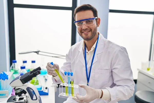 Laboratuvarda test tüpleri tutan genç İspanyol bilim adamı.