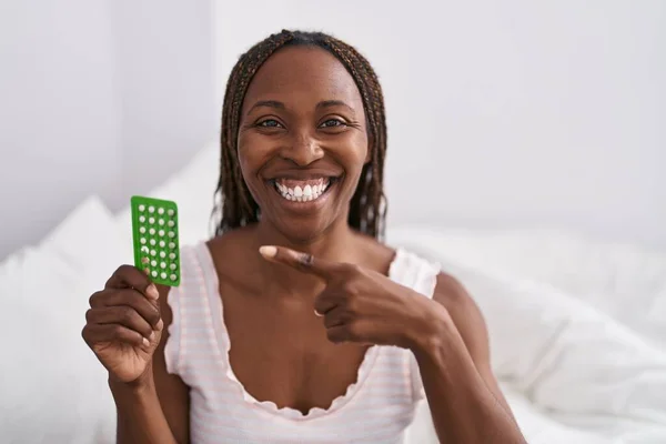 African American Woman Holding Birth Control Pills Smiling Happy Pointing — Photo
