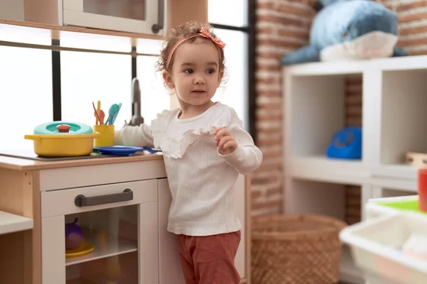 stock image Adorable caucasian girl playing with play kitchen standing at kindergarten