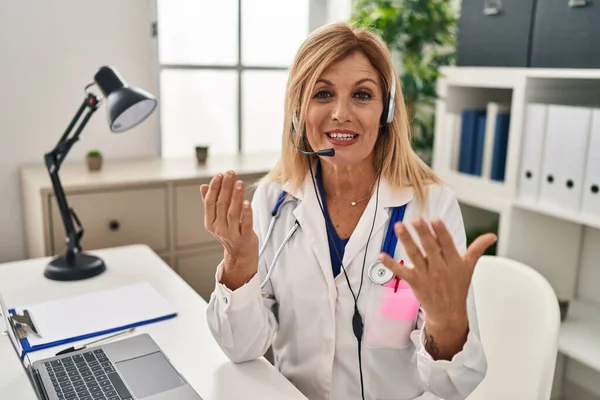 Middle Age Blonde Woman Wearing Doctor Uniform Having Medical Teleconsultation — Stock fotografie