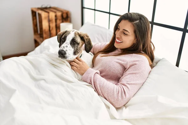Junge Frau Lächelt Selbstbewusst Und Umarmt Hund Der Auf Bett — Stockfoto