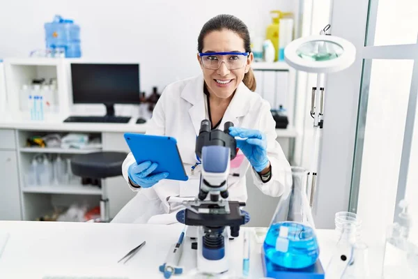 Young Hispanic Woman Wearing Scientist Uniform Using Touchpad Microscope Laboratory — Stock Photo, Image