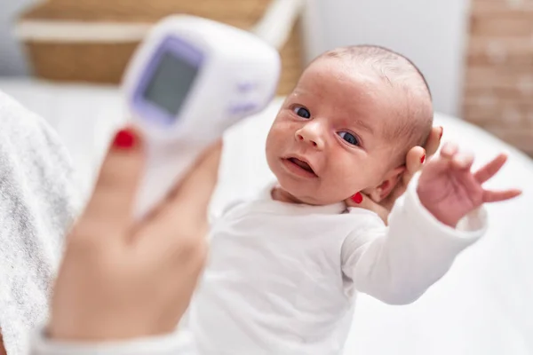 Adorable Caucasian Baby Mother Arms Measuring Temperature Bedroom — Stockfoto