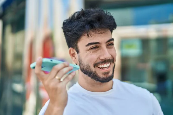 若いヒスパニック系の男笑顔自信を持ってリスニング音声メッセージによってスマートフォンでストリート — ストック写真