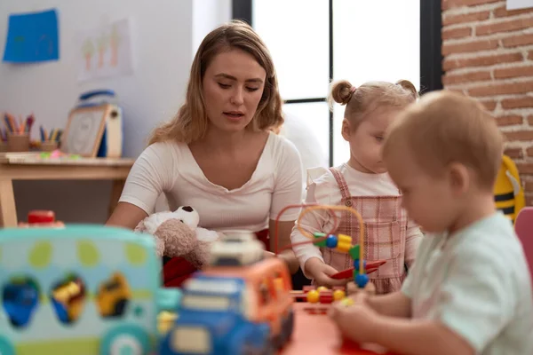 Lehrerin Mit Jungen Und Mädchen Spielt Mit Spielzeug Auf Tisch — Stockfoto