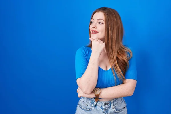 Redhead Woman Standing Blue Background Hand Chin Thinking Question Pensive — Photo