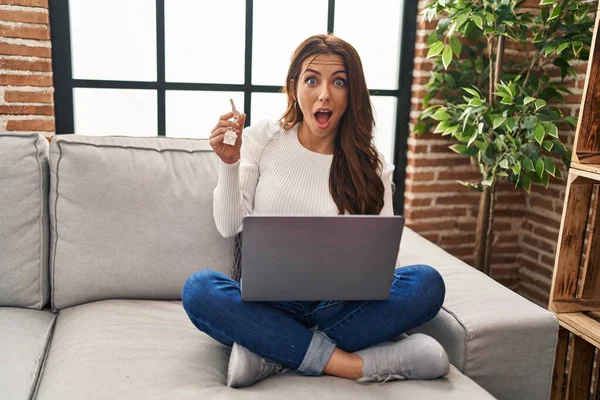 Young Brunette Woman Using Laptop Holding Keys New Home Scared — Stock Photo, Image