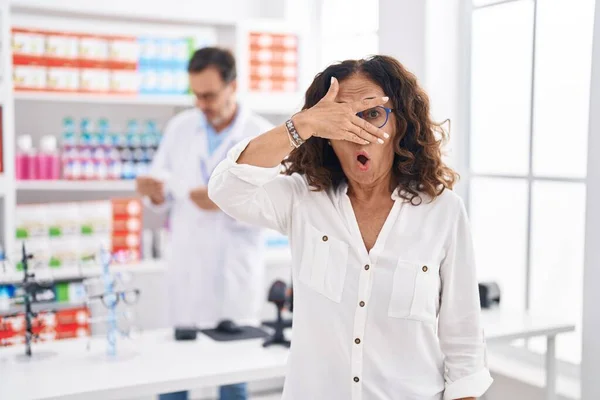Middle Age Hispanic Woman Shopping Pharmacy Drugstore Peeking Shock Covering — 스톡 사진