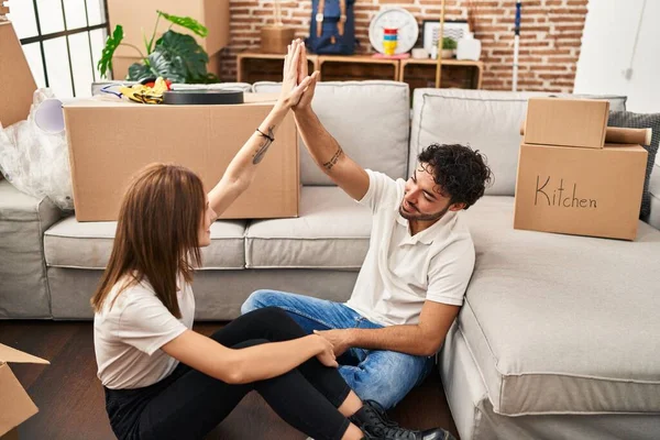 Erkek ve kadın çift gülümsüyor. Kendine güvenen bir beşlik. Yeni evlerinde eller havada.