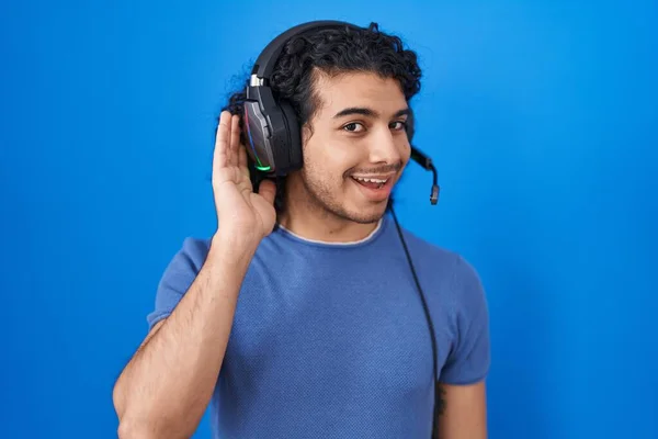 Hispanic Man Curly Hair Listening Music Using Headphones Smiling Hand — Stockfoto