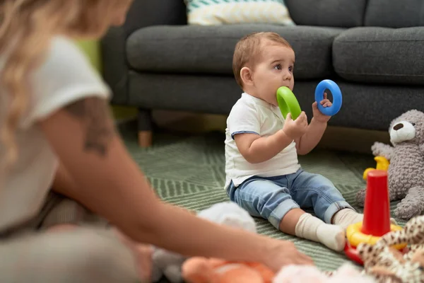 Sevimli Bebek Evde Yerde Oturan Plastik Halkayı Isırıyor — Stok fotoğraf