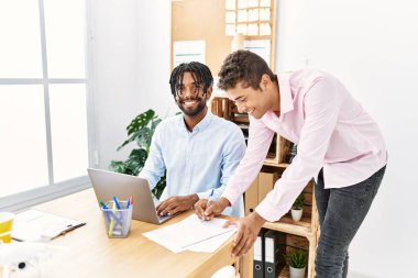 Ofiste çalışırken gülümseyen iki iş adamı.