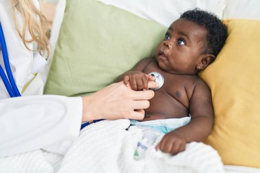 Afrika kökenli Amerikalı bebek yatak odasında muayene oluyor.