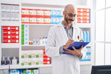 Genç İspanyol eczacı eczanedeki belgeye yazı yazıyor.