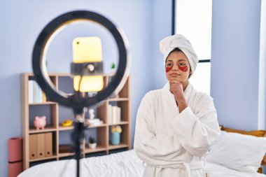 Koyu renk saçlı İspanyol bir kadın akıllı telefonuyla güzellik dersi kaydediyordu. Ciddi bir yüz ifadesi vardı. Çene üstüne çeneyle soru sormayı düşünüyordu, kafa karıştırıcı bir fikirdi. 