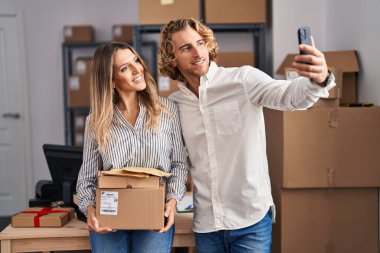 Man and woman ecommerce business workers make selfie by the smartphone at office
