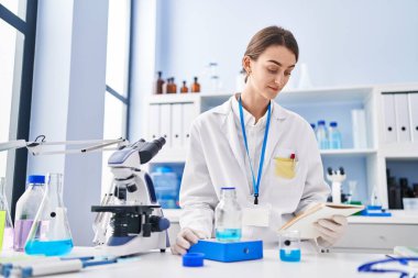 Young caucasian woman scientist stressed using laptop at laboratory