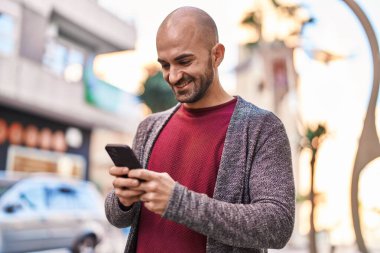 Sokakta akıllı telefon kullanan kendine güvenen genç adam.
