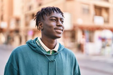 African american man smiling confident looking to the side at street