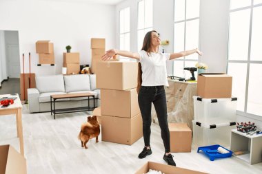 Genç İspanyol kadın yeni evinde köpekle durduğundan emin bir şekilde gülümsüyor.