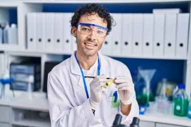 Laboratuvarda test tüpüne yazı yazan genç İspanyol bilim adamı.