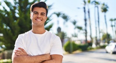 Sokakta kollarını kavuşturmuş İspanyol genç bir adam.