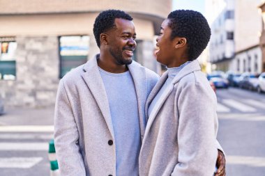 Man and woman couple hugging each other standing at street