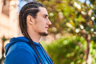 Young man with relaxed expression standing at park