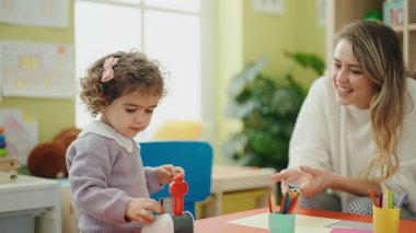 Teacher and toddler playing at kindergarten