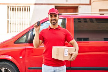 Genç İspanyol kurye paketini ve araba anahtarını sokakta tutuyor.