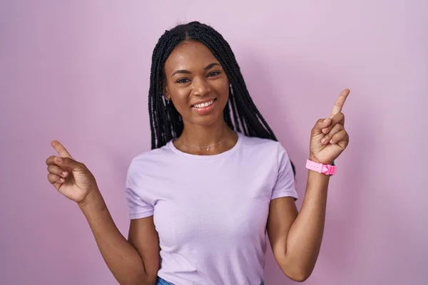 Африканская Американка Косичками Стоящая Розовом Фоне Уверенно Улыбаясь Указывая Пальцами — стоковое фото